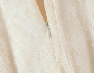 Détail macro du tissu jacquard crème et de la fermeture éclair invisible de qualité