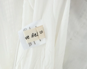 Gros plan de l'étiquette d'entretien et taille S sur une robe blanche en dentelle