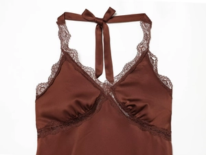 Detail of dark brown satin top featuring elegant lace trim and a halter neck bow tie