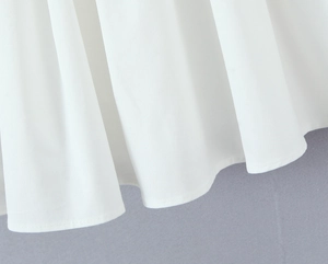 Detailed view of the pleated white fabric hem with premium diagonal twill texture