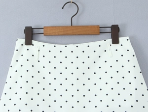 Detail view of white fabric with black polka dots featuring waist belt loops and smooth texture