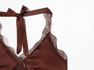 Detail of silk satin top featuring exquisite floral eyelash lace and bow ribbon ties