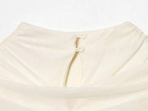 Detail of cream mesh dress featuring a high neck with dual white button back closure