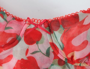 Detail of red floral camisole neckline featuring a dainty bow and mesh scalloped trim