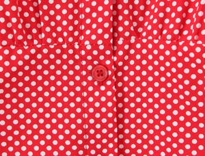 Close-up of a red polka dot shirt showing button detail and high-quality cotton fabric
