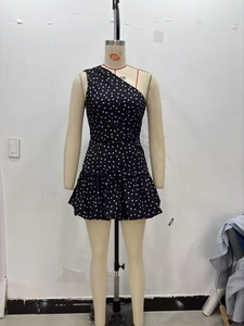Detail of black one-shoulder polka dot dress with layered ruffle hem and asymmetric design