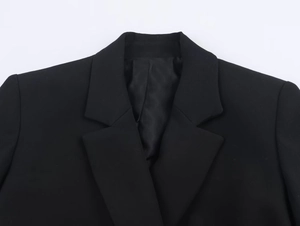 Détail du revers d'un blazer noir classique et texture de tissu en sergé de qualité