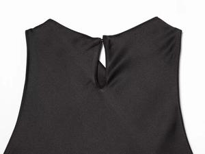 Detail of the back neckline with keyhole opening and button on a black satin dress
