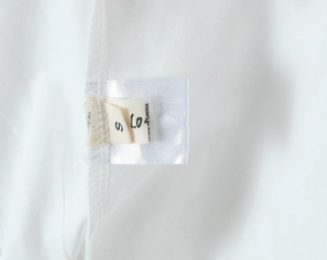 Detail view of the white clothing care label showing size S and Made in China tag