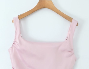 Detail of light pink summer dress featuring square neckline and pleated shoulder straps
