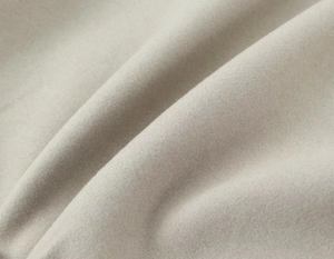 Gros plan sur la texture du tissu en laine gris clair doux avec des plis et fibres premium