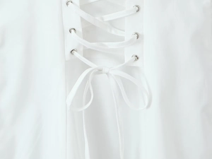 Detail of white dress with silver eyelets and cross-lacing design with a neat bow tie