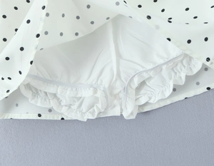 Detail of the white polka dot skirt showing built-in elastic safety lining with ruffles