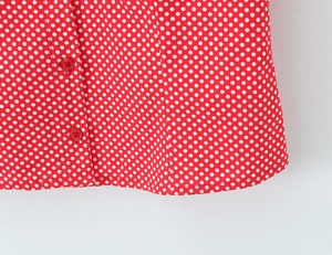 Close-up of red polka dot shirt with matching resin buttons and neat stitching