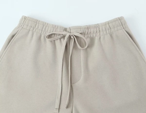 Détail de la taille élastique beige avec cordon plat et texture de tissu brossé doux