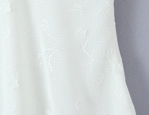 Macro view of pure white floral lace fabric with intricate mesh patterns and textures
