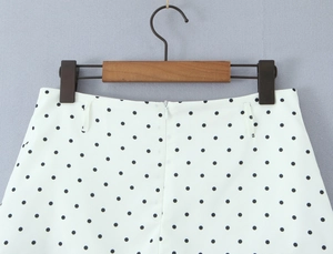 Detail of white polka dot skirt waist featuring invisible zipper and belt loops