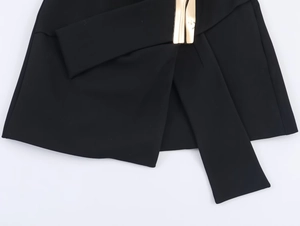 Détail de la taille noire avec design croisé et boucle métallique dorée décorative