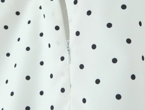 Detail shot of the invisible zipper closure on white polka dot printed summer set