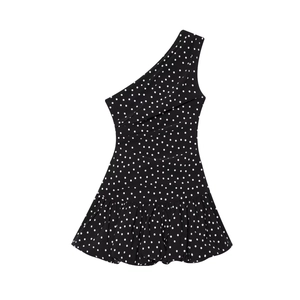Detail of white polka dots on black asymmetric dress with layered pleats and ruffles