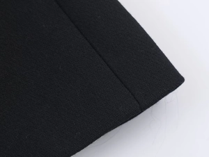 Gros plan détaillé sur la texture du tissu noir et les coutures précises du pantalon habillé