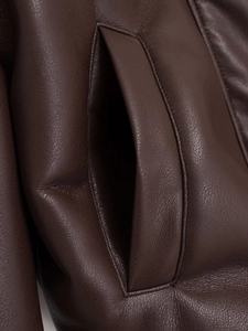 Macro shot of dark brown pebbled leather texture and reinforced side pocket stitching