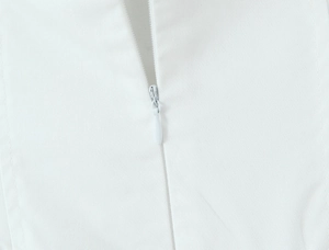 Close-up of the invisible zipper and twill fabric texture on a white halter dress