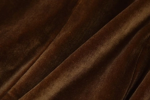 Primer plano de textura de terciopelo marrón con brillo suave y caída muy elegante