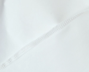 Macro shot of fine edge stitching and smooth white fabric texture on a summer dress