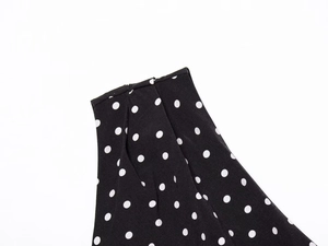 Detailed view of polka dot pattern fabric with high-quality stitching on waistline