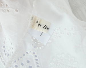 Macro detail of summer dress showing eyelet lace fabric and size S label for women