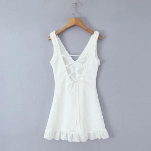Detail view of white lace sleeveless dress with deep V-neck and ruffled hemline