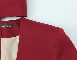 Detail of burgundy blazer showing black neck label and luxury champagne satin lining