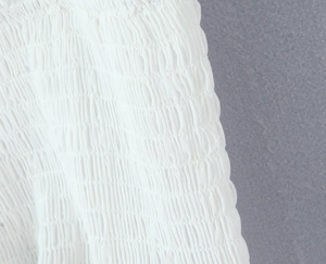 Detailed close-up of white summer set featuring smocked elastic texture and cotton fabric
