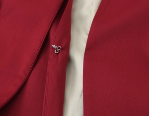 Detailed macro view of dark red blazer metal hook closure with cream beige inner lining