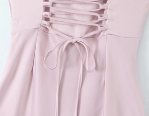 Detail of cross-straps and bow tie on the back of a pink satin fishtail dress