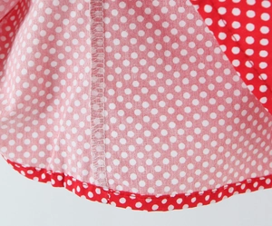 Close-up of red and white polka dot fabric showing detailed stitching and hem finishing