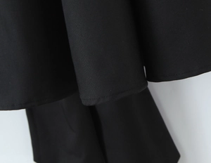 Gros plan détaillé de l'ourlet sur cette robe d'été noire ajustée avec dos nu sexy