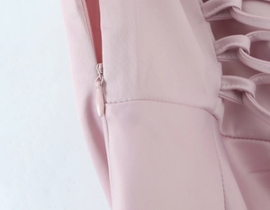 Detail view of pink mermaid dress featuring hidden zipper and criss-cross lace-up design