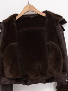 Close-up of dark brown faux leather jacket with plush fur lining and metal zipper detail
