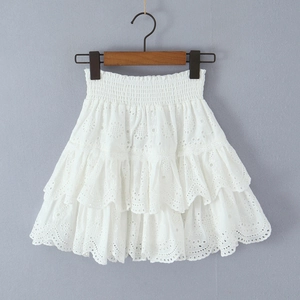 Close-up of tiered white lace skirt with floral embroidery and smocked elastic waist