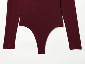 Detail view of burgundy long sleeve bodysuit with thong cut and high leg leg openings