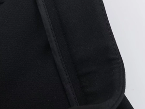 Gros plan sur un tissu textile noir avec coutures précises et bordures en soie