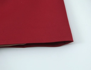 Close-up of deep red woven fabric texture showing detailed fine knit of the skirt hem