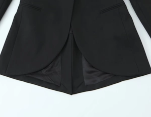 Détail de la veste de costume noire avec ourlet incurvé unique et design multicouche