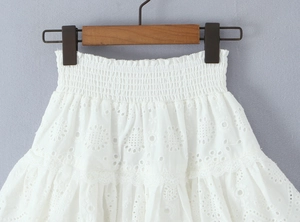Detailed view of white lace embroidery skirt with elastic waist and hollowed floral patterns