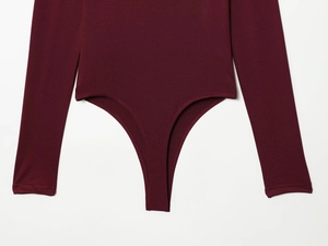 Detailed view of dark red knit bodysuit with long sleeves and high-cut leg opening