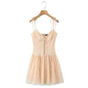 Detailed close-up of lace embroidery and corset-style lace-up front on apricot dress
