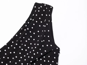 Detailed macro shot of a black polka dot dress featuring a seamless side invisible zipper