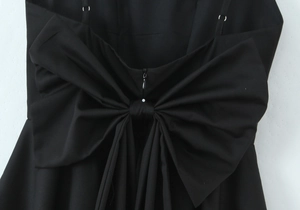 Détail du nœud au dos d'une robe d'été noire ajustée avec des bretelles réglables